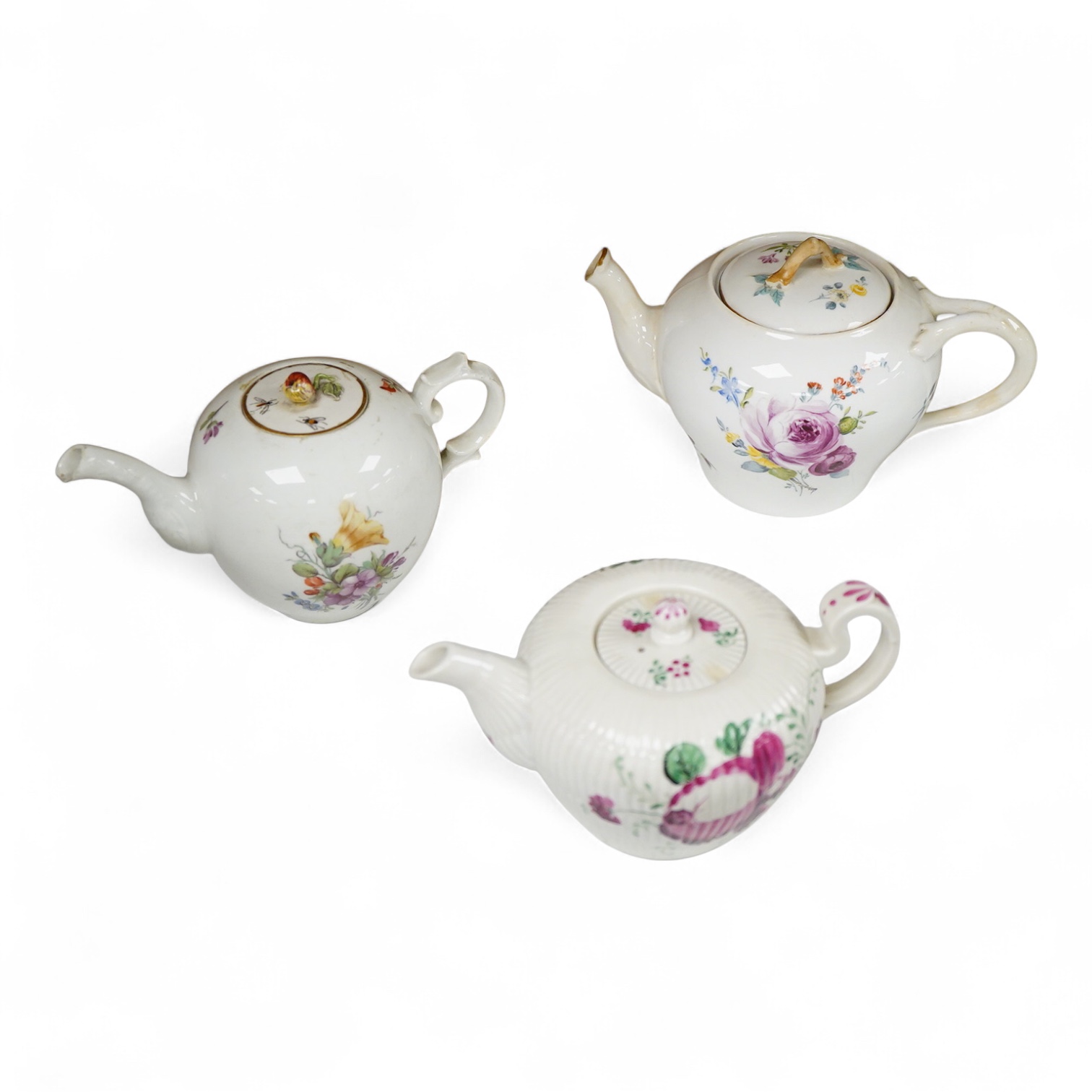 An 18th Furstenburg porcelain teapot and cover, a Wallendorf porcelain teapot and cover and a Meissen style teapot, 12cm high
